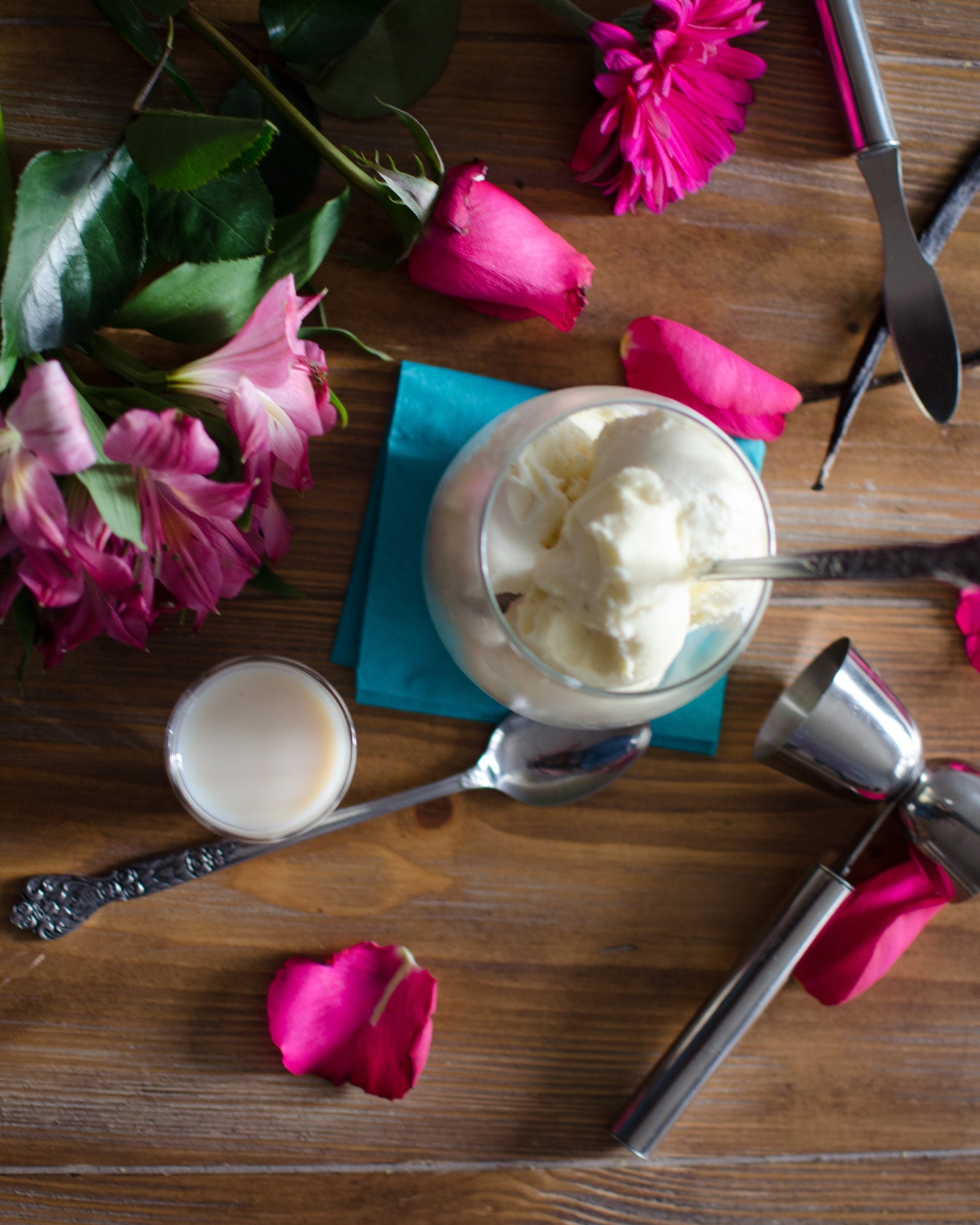 Vanilla Bean Horhcata in a glass with pink florals surrounding it on a wooden table