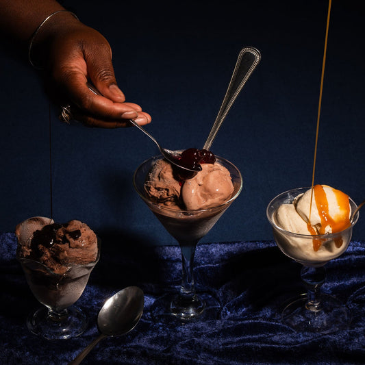 Scoops of alcoholic ice cream with various toppings served in cocktail glasses